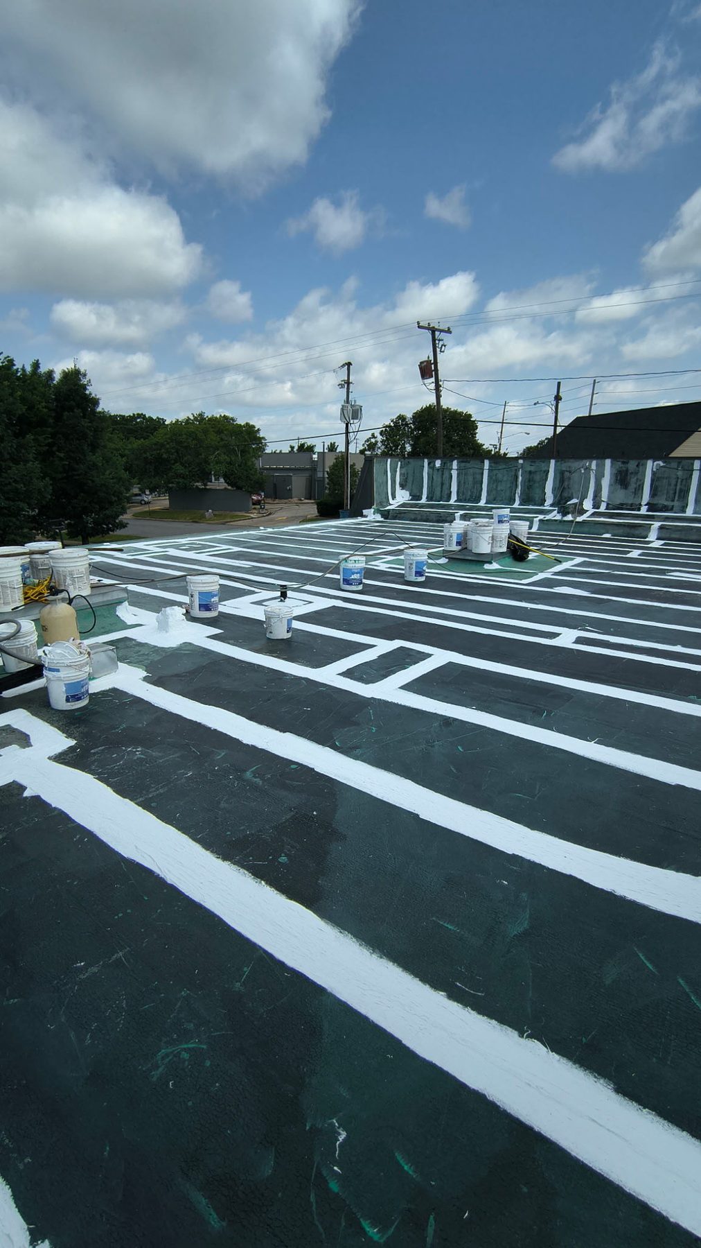 Flat commercial roof mid-restoration, seams and flashings coated.