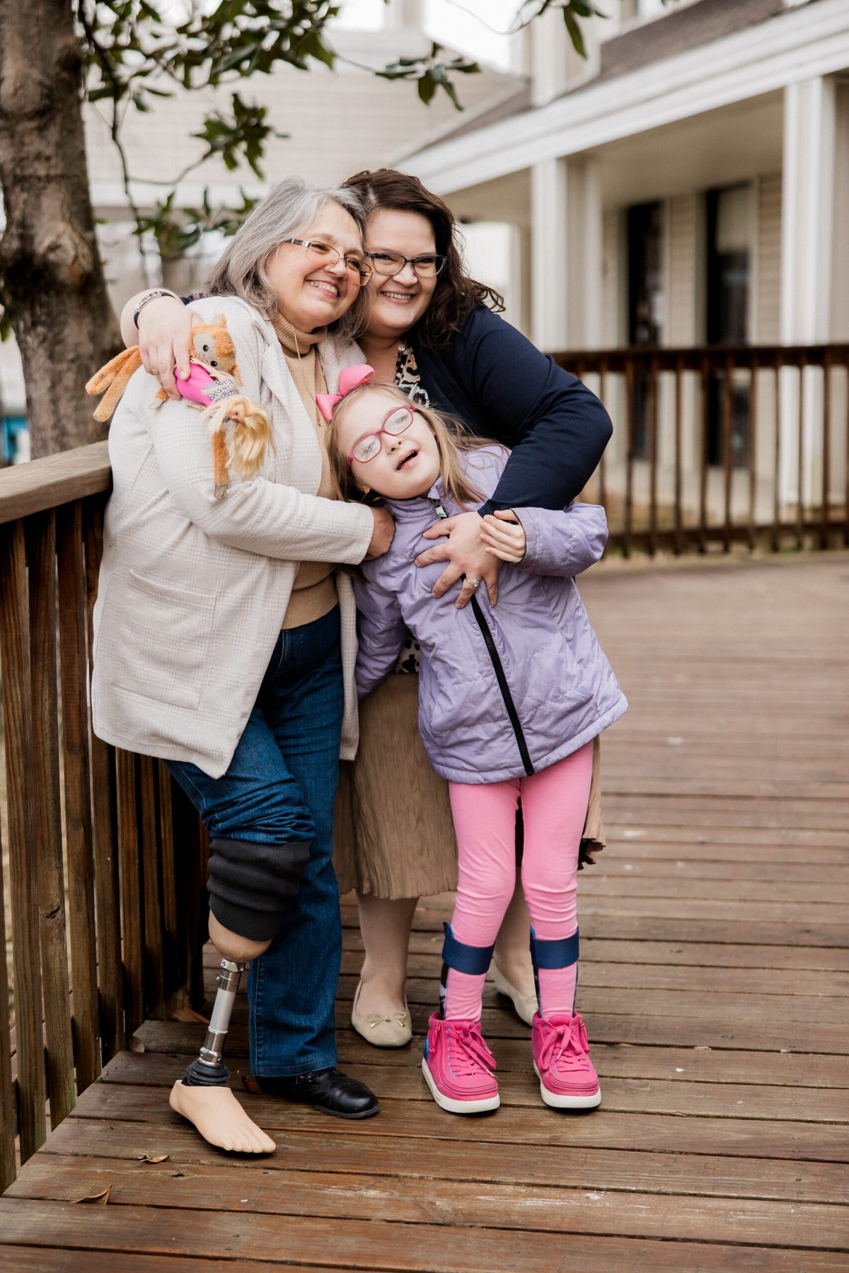 Three generations of a family on a porch; the grandmother wears a below-knee prosthesis.