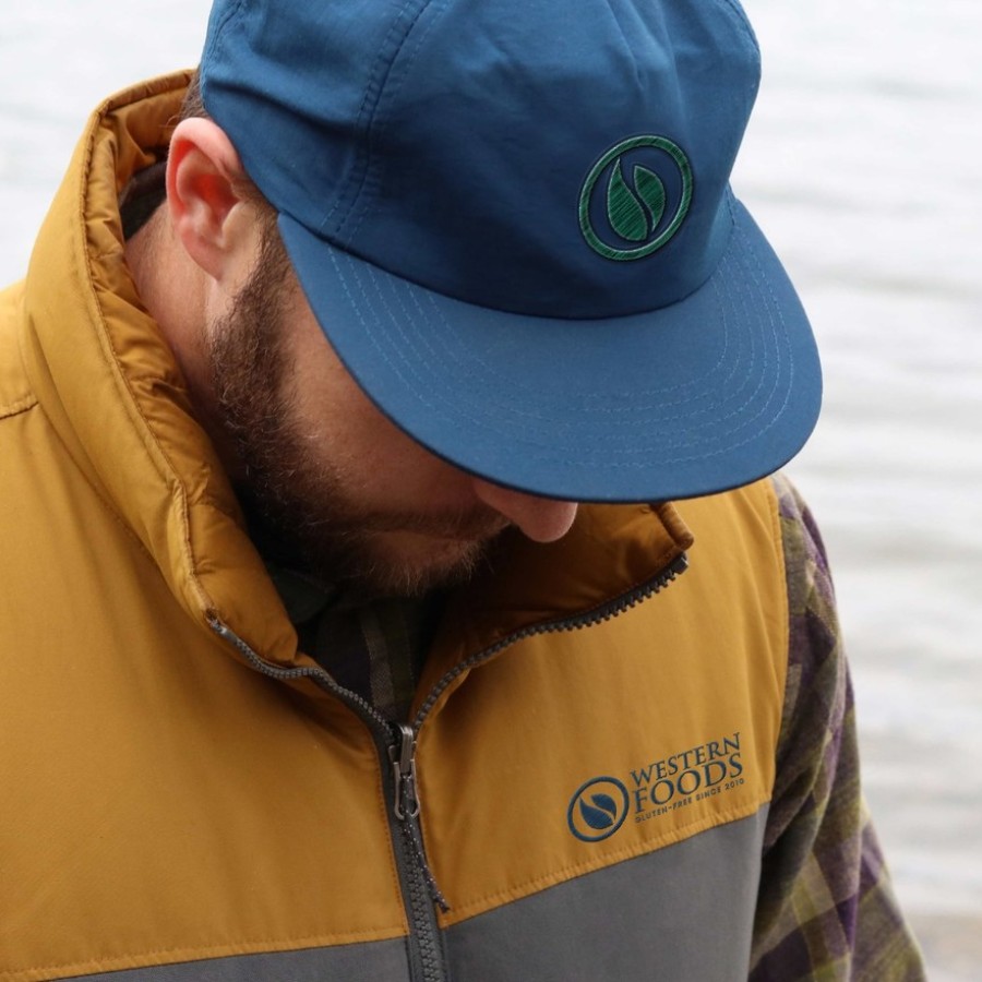 A Western Foods branded cap and vest worn on location, the refreshed mark embroidered on both